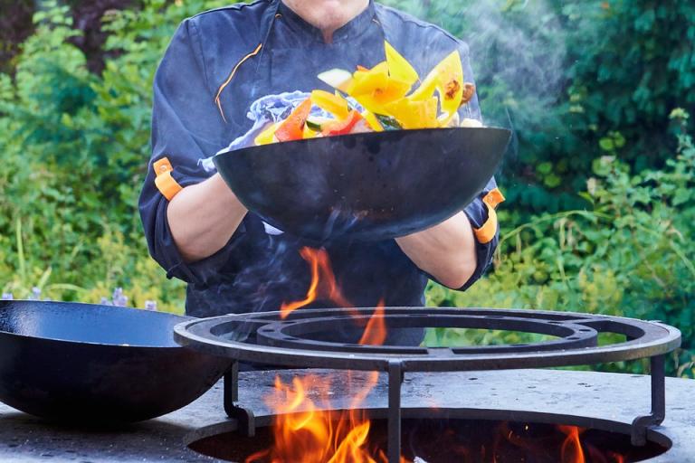 Cooking vegetables in a wok on fire